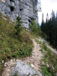 úzkou pěšinkou podél skalních stěn,