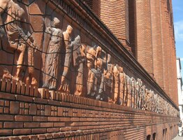 s dlouhatánskou stuhou figurální výzdoby v průčelí