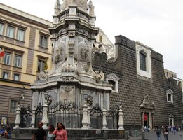 Před chrámem stojí vysoký mariánský sloup