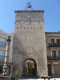 s městskou branou na stinném náměstíčku