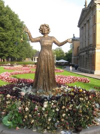 V parku před ním je tato veselá paní