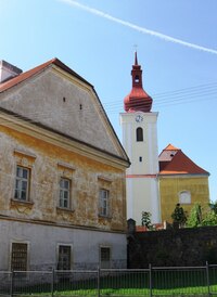 a před větším kostelem zašlý statek